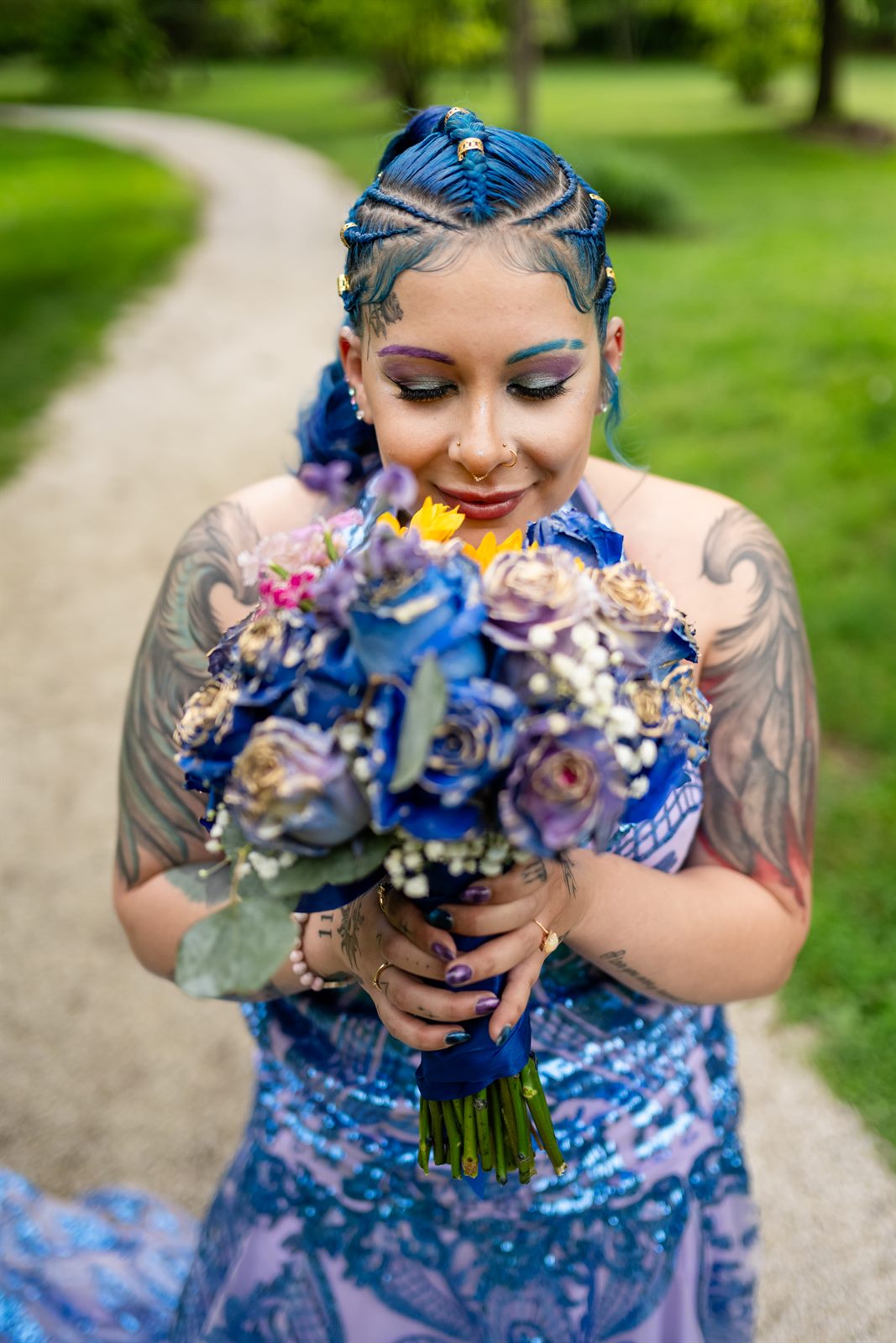 Bride with blue braided hair smelling her bouquet before her wedding
