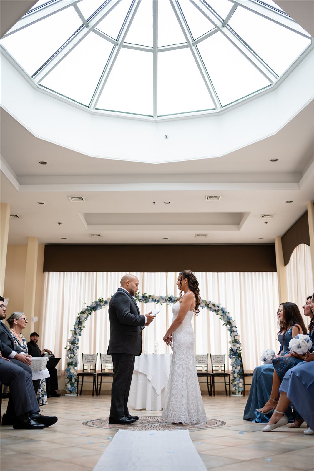 Groom reading his vows beneath a domed skylight at a Philadelphia wedding ceremony