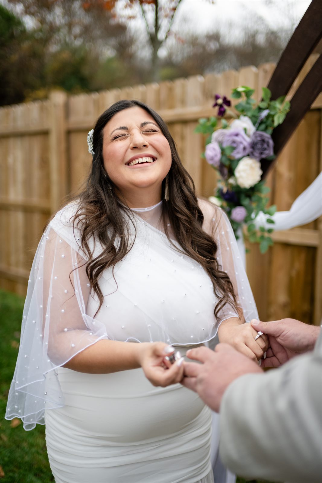 Bride laughing joyfully during her backyard elopement ring exchange