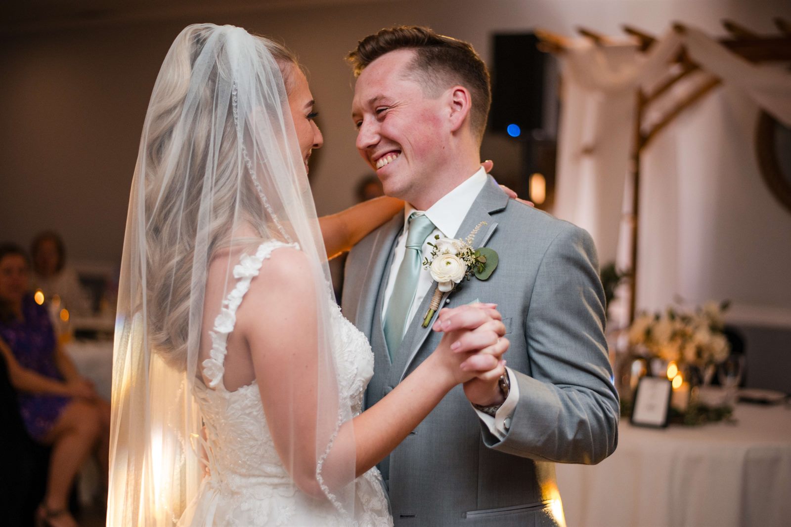 Groom grinning at his bride during their first dance