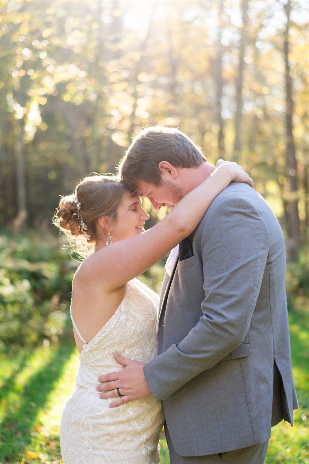 Bride and groom forehead to forehead in golden autumn light
