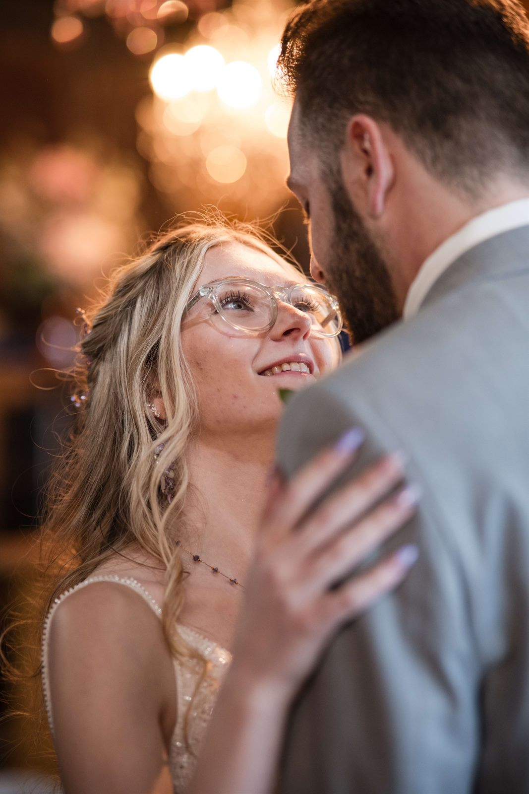 Bride gazing up at her groom during golden hour at their wedding reception