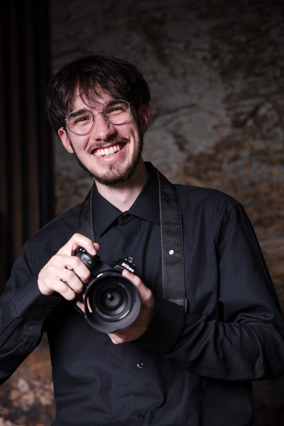 Nick Schluth laughing with his camera in hand