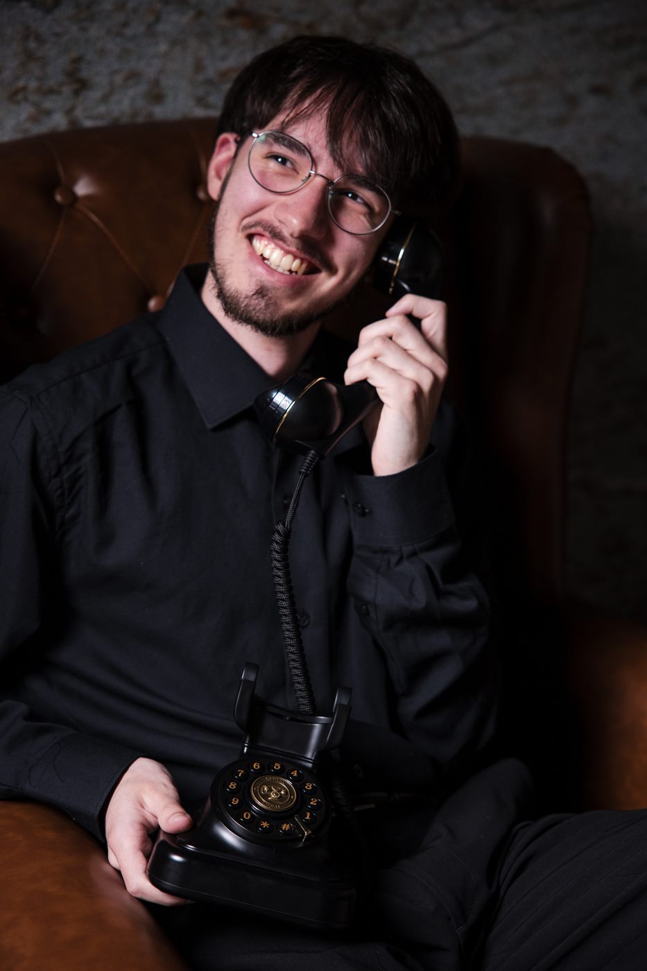 Nick laughing while taking a call on a vintage rotary telephone
