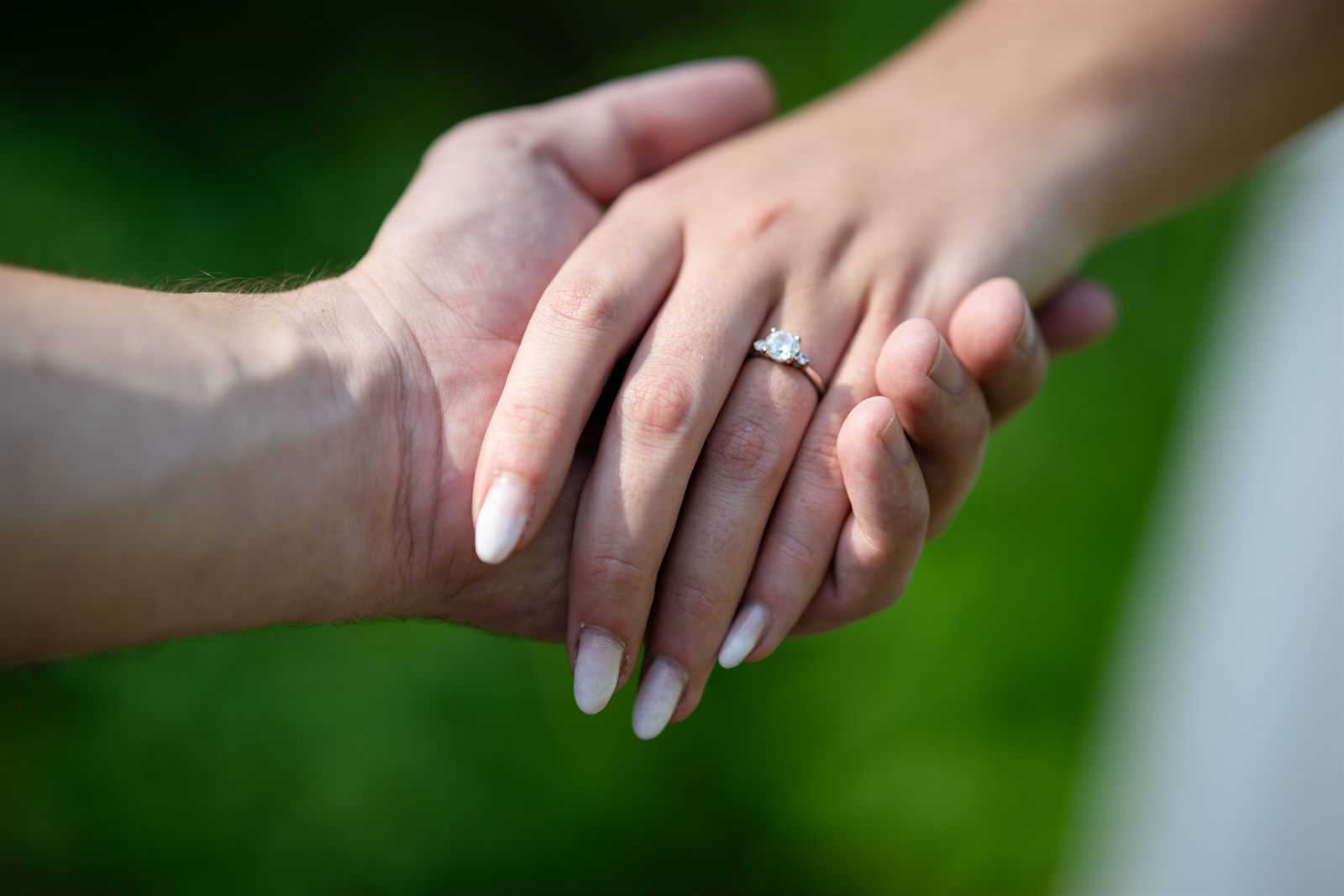 Close-up of the couple's hands with the engagement ring